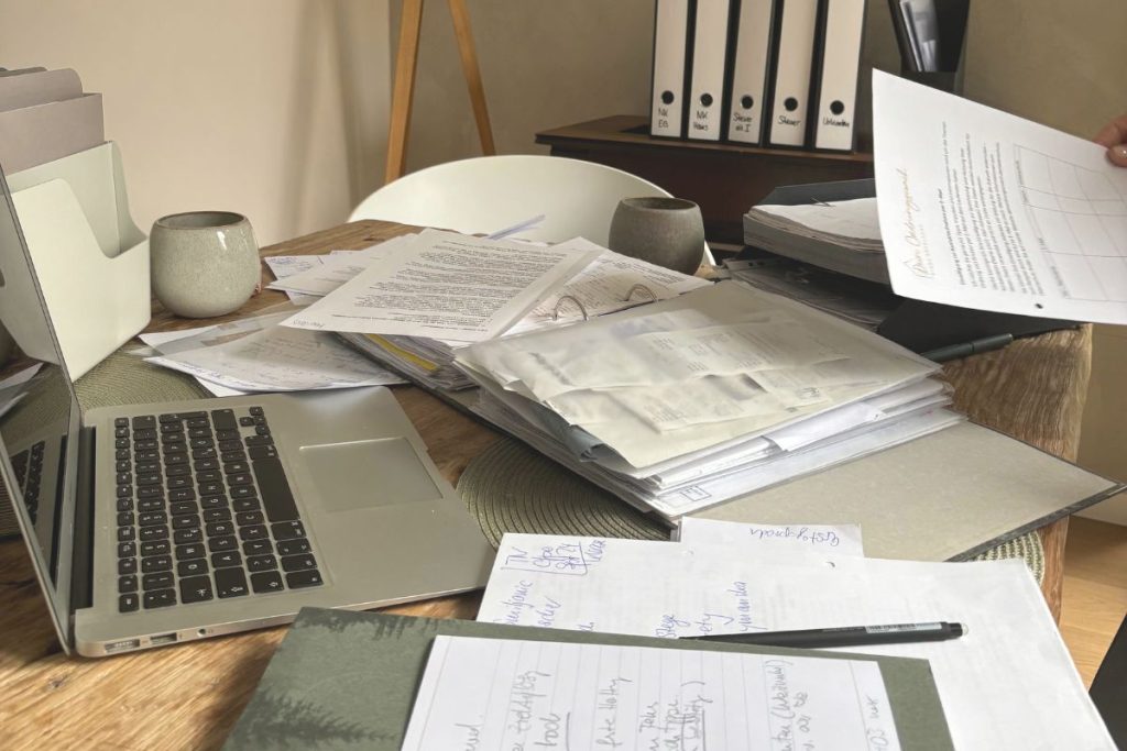 Papierstapel und Notizen auf einem Schreibtisch im Homeoffice