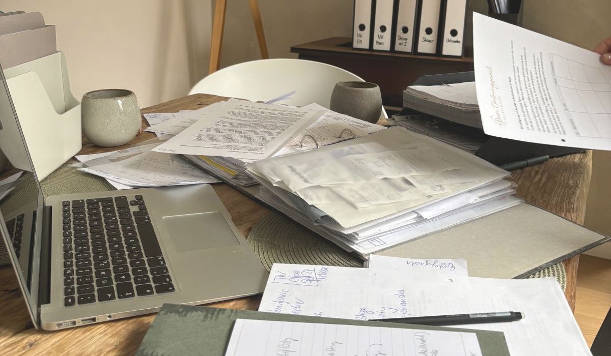 Papierstapel und Notizen auf einem Schreibtisch im Homeoffice